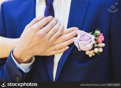 Wedding rings on hands of bride and groom. Close up photo