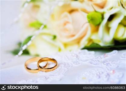 wedding rings with bouquet from roses