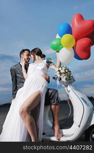 wedding sce of bride and groom just married couple on the beach ride white scooter and have fun