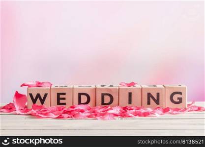 Wedding sign with rose leaves on a wooden table