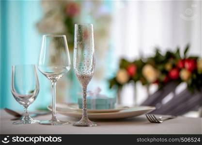 Wedding table decoration. Festive table setting with decorated glasses and dishes. Three decorated glasses and dishes on wedding table.
