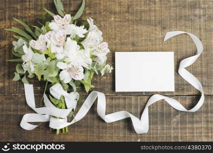 wedding white card peruvian lily flower bouquet tied with ribbon wooden desk