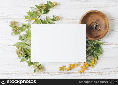 wedding white card rings flowers yellow berries white wooden desk