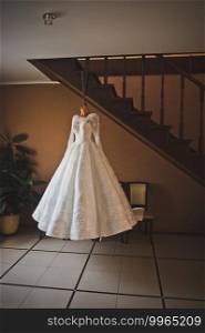 Wedding white dress on a mannequin hanging on the stairs.. A mannequin with a white wedding dress is hanging in the stairwell 2624