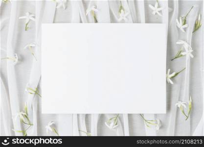 wedding white placard surrounded with jasminum auriculatum flowers scarf
