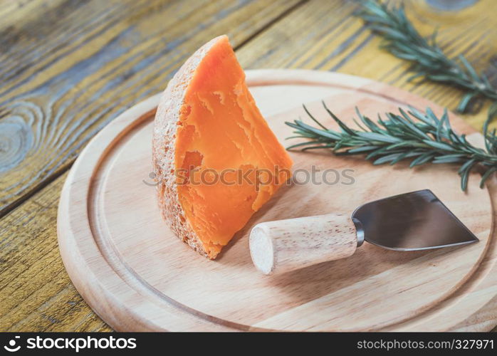 Wedge of Mimolette cheese on the wooden board