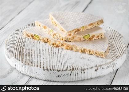 Wedges of turron nougat confection on wooden board