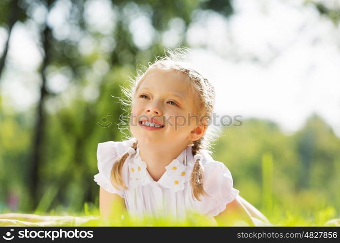 Weekend in park. Little cute girl in summer park reading book