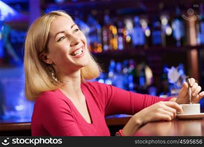 Weekend party. Young attractive lady at bar talking on phone