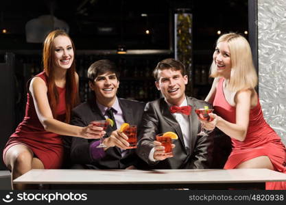 Weekend party. Young attractive people of four having cocktail party