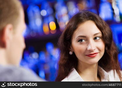 Weekend party. Young couple in bar having drinks and talking