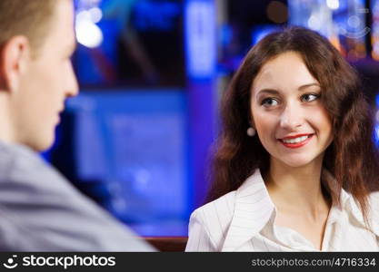 Weekend party. Young couple in bar having drinks and talking