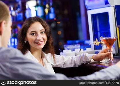 Weekend party. Young couple in bar having drinks and talking