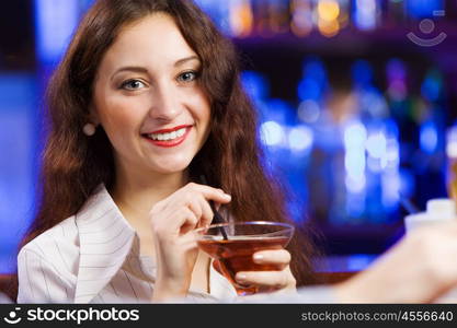 Weekend party. Young pretty girl at bar drinking cocktail