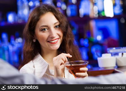 Weekend party. Young pretty girl at bar drinking cocktail