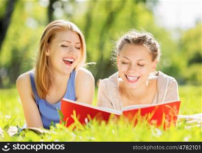 Weekend picnic. Young pretty girls in summer park reading book