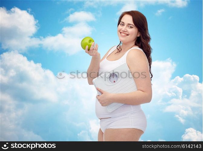 weight loss, diet, slimming, healthy eating and people concept - happy young plus size woman in underwear holding scales and green apple over blue sky and clouds background