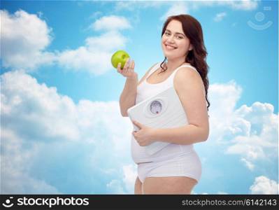 weight loss, diet, slimming, healthy eating and people concept - happy young plus size woman in underwear holding scales and green apple over blue sky and clouds background