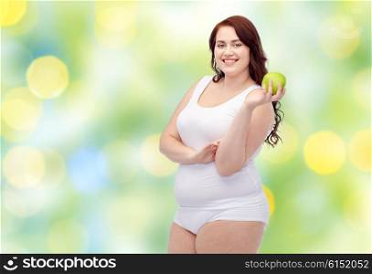 weight loss, diet, slimming, healthy eating and people concept - happy young plus size woman in underwear with green apple over green lights background
