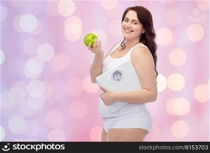 weight loss, diet, slimming, healthy eating and people concept - happy young plus size woman in underwear holding scales and green apple over pink holidays lights background