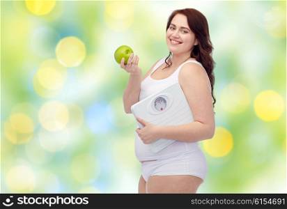 weight loss, diet, slimming, healthy eating and people concept - happy young plus size woman in underwear holding scales and green apple over green lights background