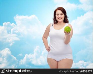 weight loss, diet, slimming, healthy eating and people concept - happy young plus size woman in underwear with green apple over blue sky and clouds background