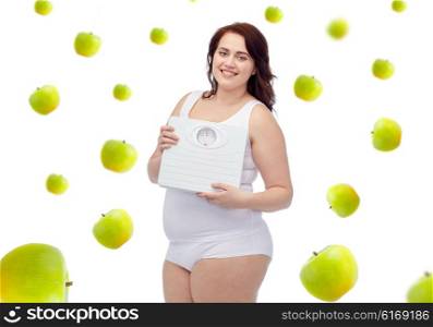 weight loss, diet, slimming, healthy eating and people concept - happy young plus size woman in underwear holding scales over green apples background