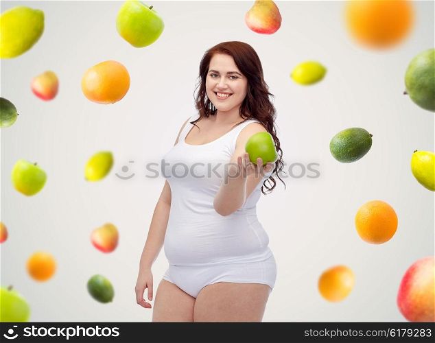 weight loss, diet, slimming, healthy eating and people concept - happy young plus size woman in underwear with green apple over fruit background