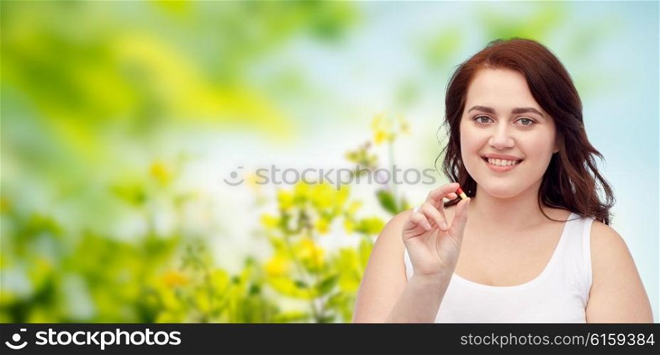 weight loss, diet, slimming, medicine and people concept - happy plus size woman in underwear with pill over green natural herbal background