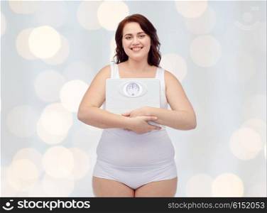 weight loss, diet, slimming, plus size and people concept - happy young plus size woman in underwear holding scales over holidays lights background