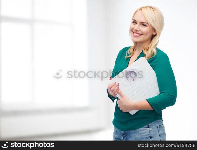 weight loss, diet, slimming, plus size and people concept - smiling young woman holding scales over white room background