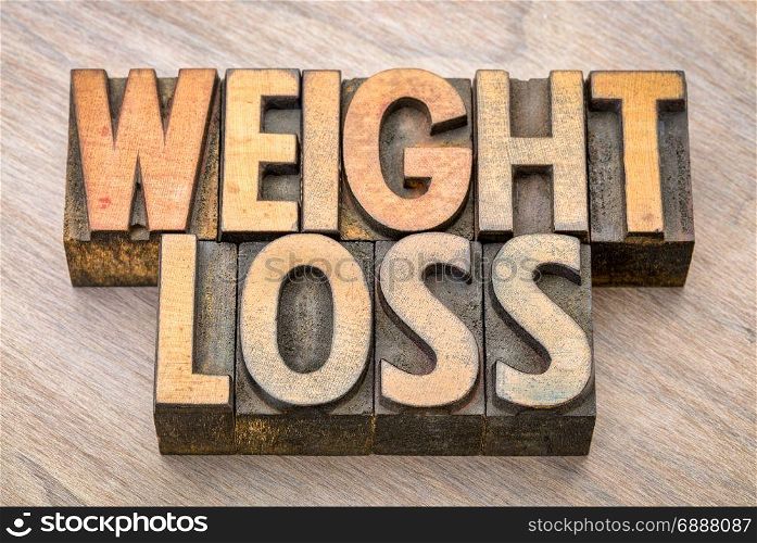 weight loss word abstract in vintage letterpress wood type against grained wooden background