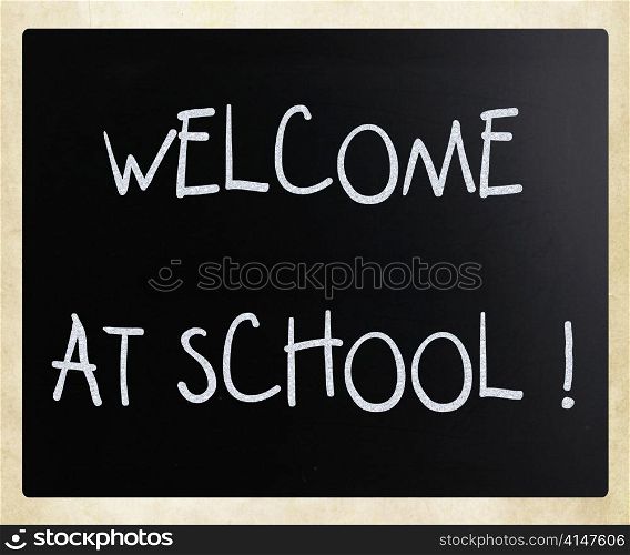 ""Welcome at school" handwritten with white chalk on a blackboard"