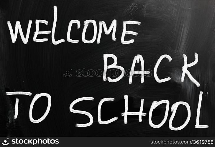""Welcome back to school" handwritten with white chalk on a blackboard"