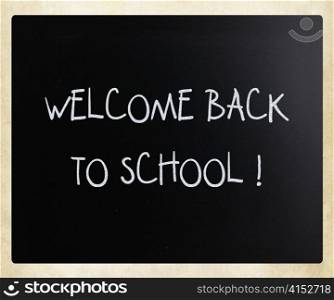 ""Welcome back to school" handwritten with white chalk on a blackboard"