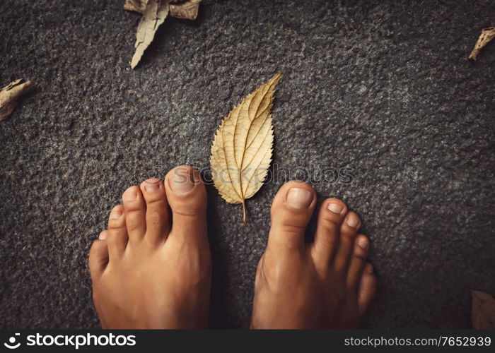 Welcome Fall Background. Closeup Concept Photo of a Barefoot Women Feet and Dry Leaves. Autumn Season Theme.