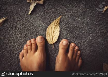 Welcome Fall Background. Closeup Concept Photo of a Barefoot Women Feet and Dry Leaves. Autumn Season Theme.
