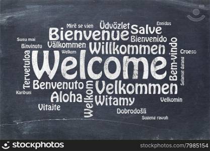 Welcome in different languages - a word cloud in white chalk text on a vintage slate blackboard