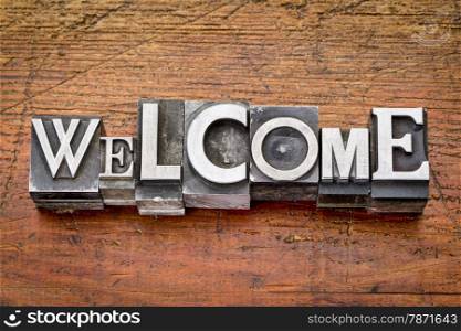 welcome word in vintage metal type printing blocks over grunge wood, mixed fonts in style and size