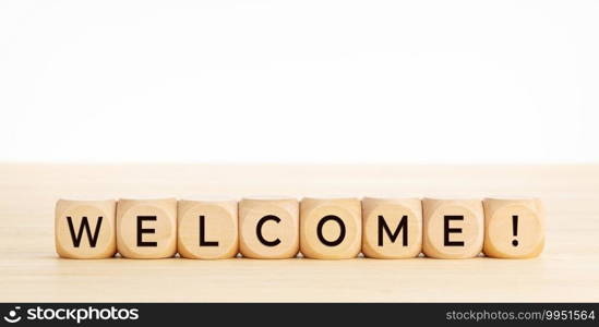 WELCOME word on wooden blocks on wood table. Copy space. White background