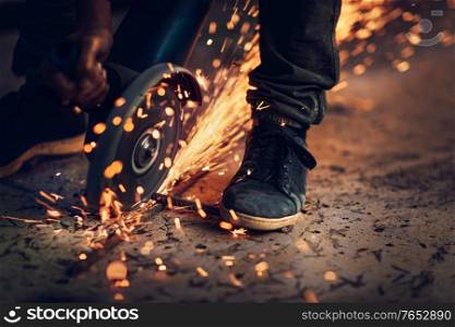 Welder at work, closeup photo of hot bright sparks fly out from under the welding, hard work, blue collar workers