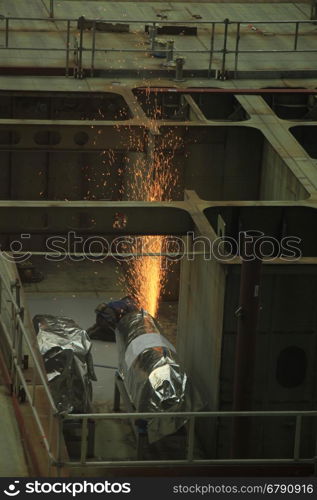 Welder at work in a shipyard, heavy industry