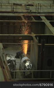 Welder at work in a shipyard, heavy industry