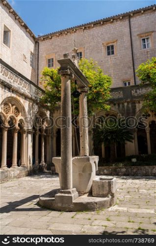 Well and cloisters of Franciscan Monastery in the old town of Dubrovnik in Croatia. Franciscan Monastery and Museum in Dubrovnik old town