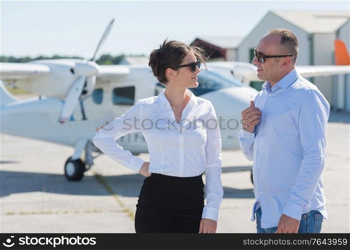 well dressed man and woman in conversation at airfield