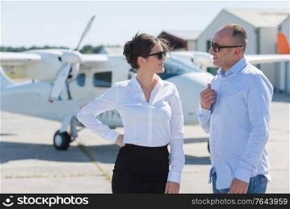 well dressed man and woman in conversation at airfield