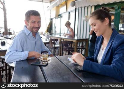 well dressed man and woman sat in cafe terrace