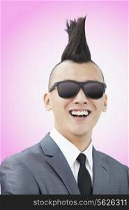 Well-dressed young man with Mohawk and sunglasses smiling