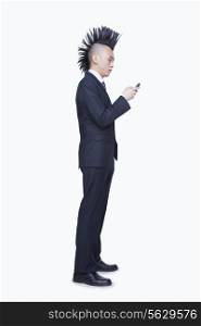 Well-dressed young man with Mohawk using mobile phone