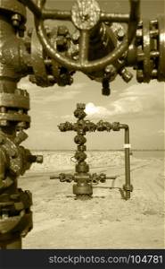 Wellhead with valve armature. Oil, gas industry. Toned sepia. Wellhead. Concept oil and gas industry.